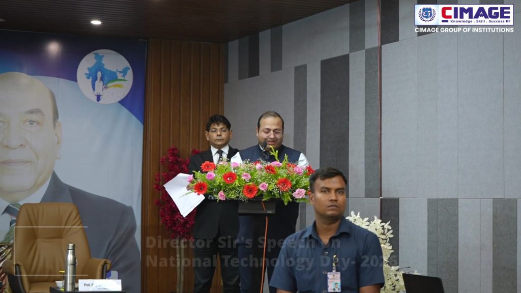 Prof. Dr. Neeraj Agrawal speaking at a decorated podium.